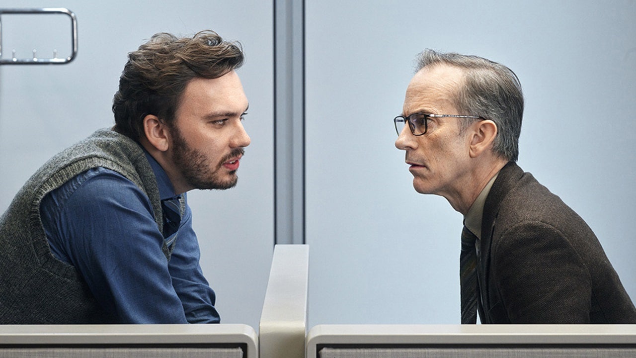 Two male colleagues engaged in an intense face-to-face discussion in a modern office setting, representing deep collaboration and problem-solving