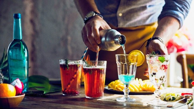 Person pouring drink to glass