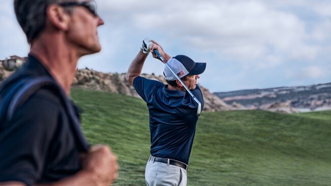 A golfer preparing to swing on a green golf course