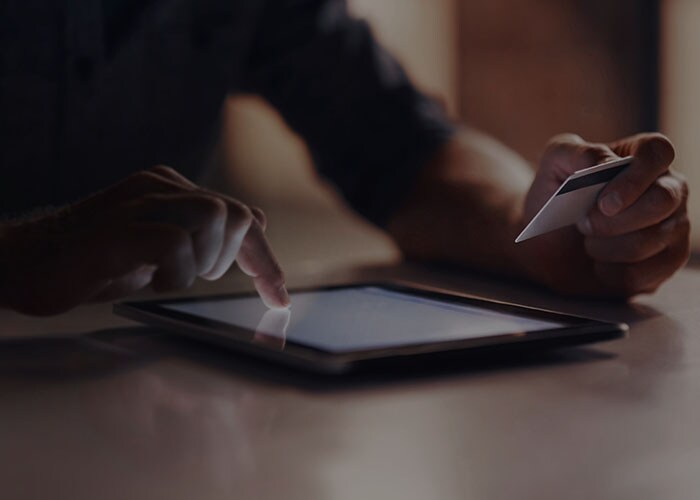 Close-up of a person’s hand making online payment using their credit card on their tablet. 